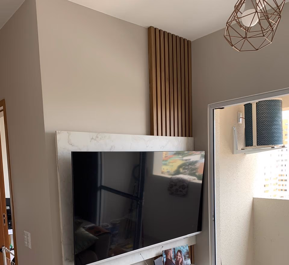 Foto do projeto: Sala com painel em efeito mármore, em Brasília, DF